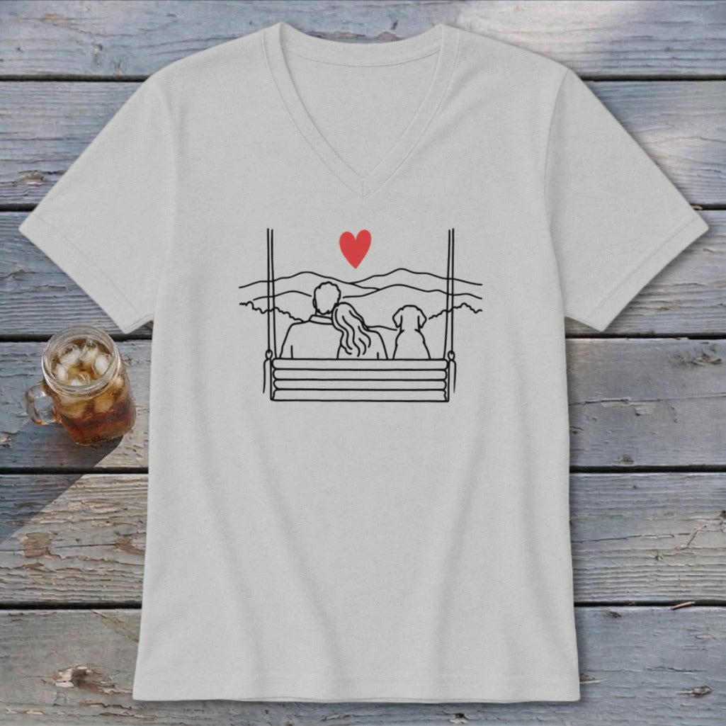 Couple and dog on a swing with heart and mountain backdrop.