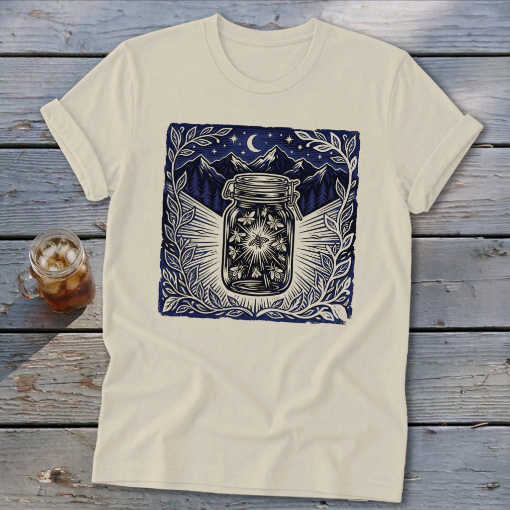 Cream t-shirt with a graphic of fireflies in a mason jar at night.