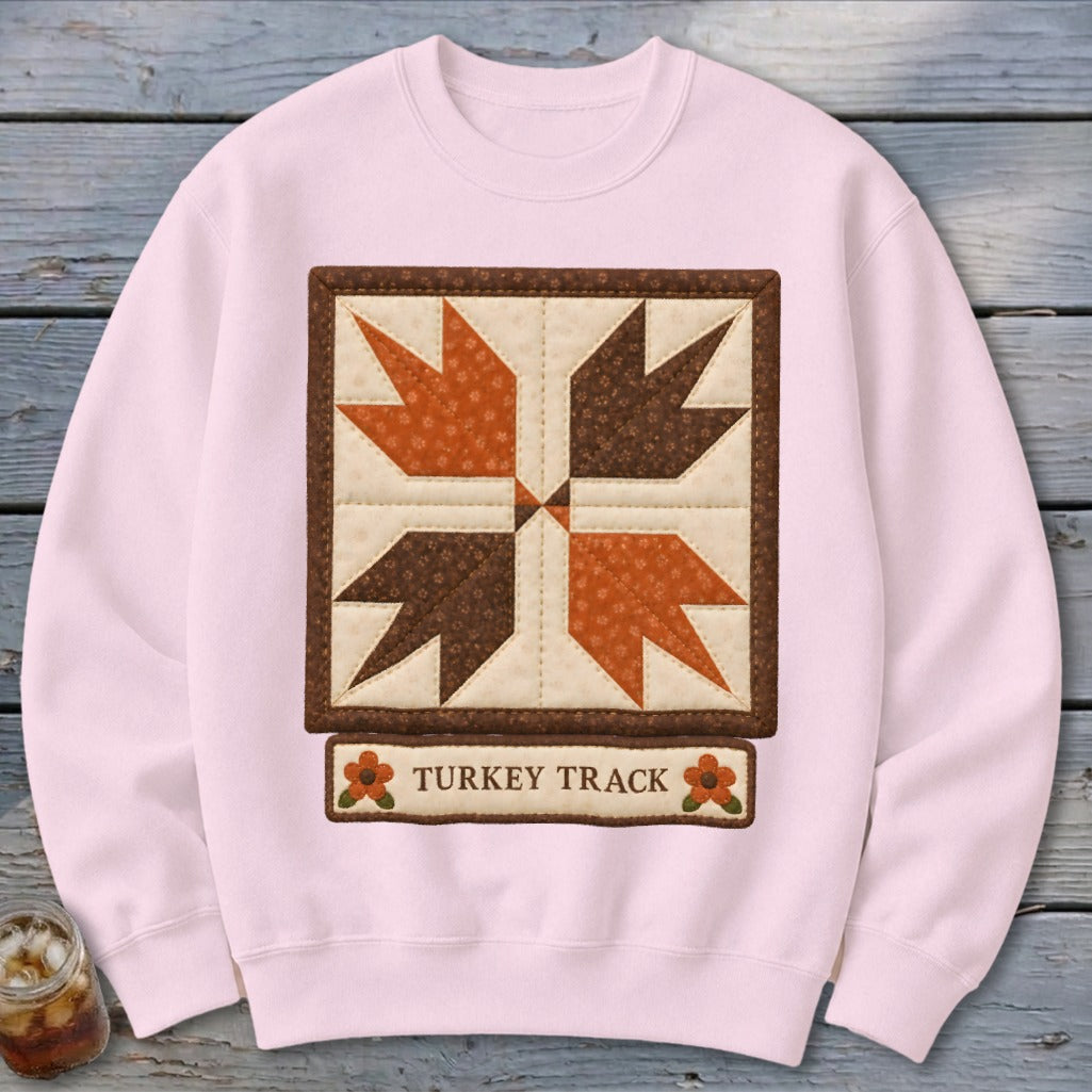 Light pink sweatshirt with a "Turkey Track" quilt block design and text.