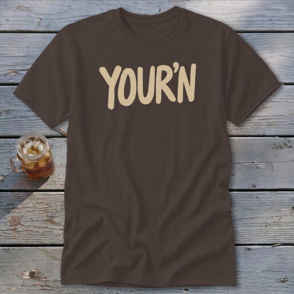 Brown t-shirt with cream text reading "YOUR'N" and a glass of iced drink.