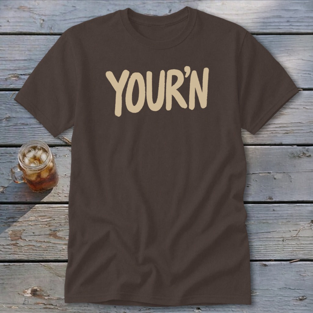 Brown t-shirt with cream text reading "YOUR'N" and a glass of iced drink.