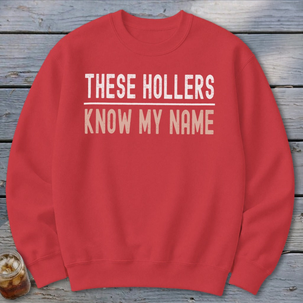 Red sweatshirt with white text "THESE HOLLERS KNOW MY NAME"