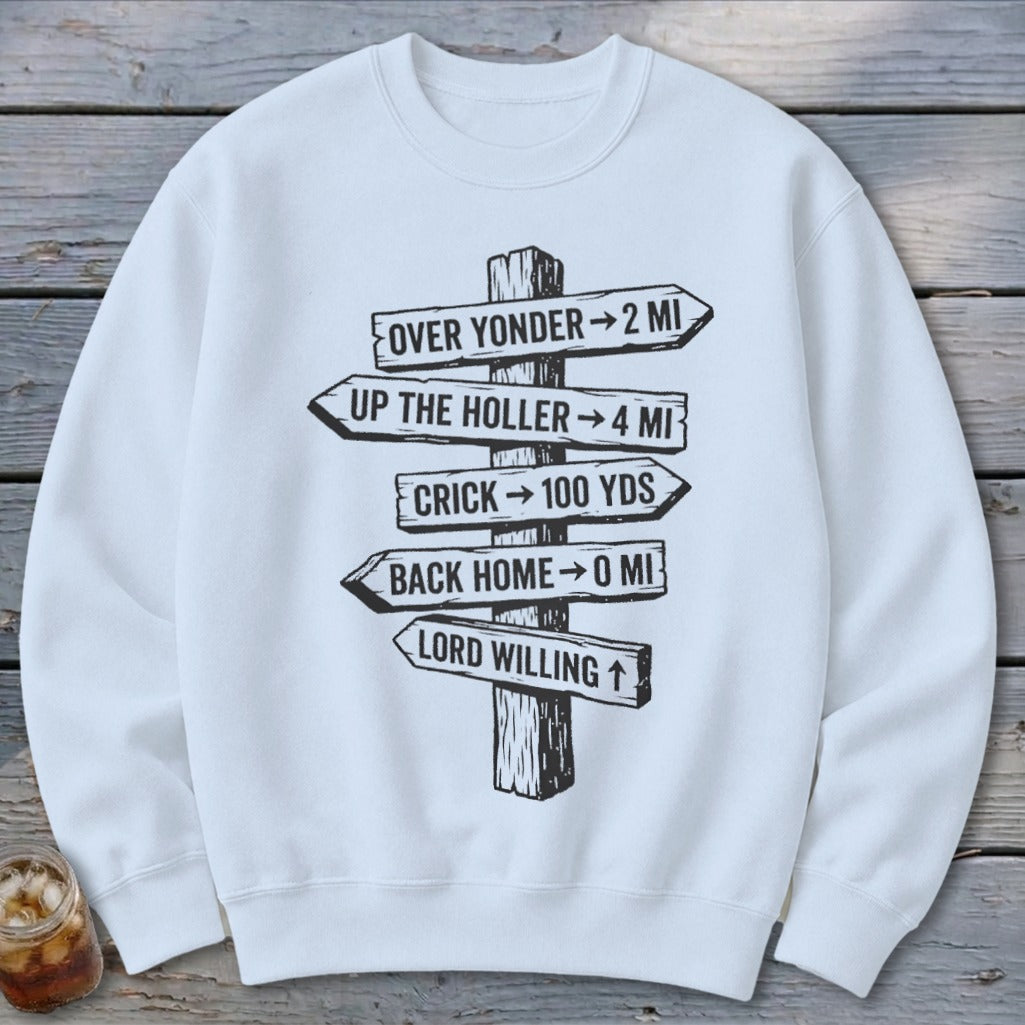 A white crewneck sweatshirt features a black graphic of a wooden signpost with directional distance text.