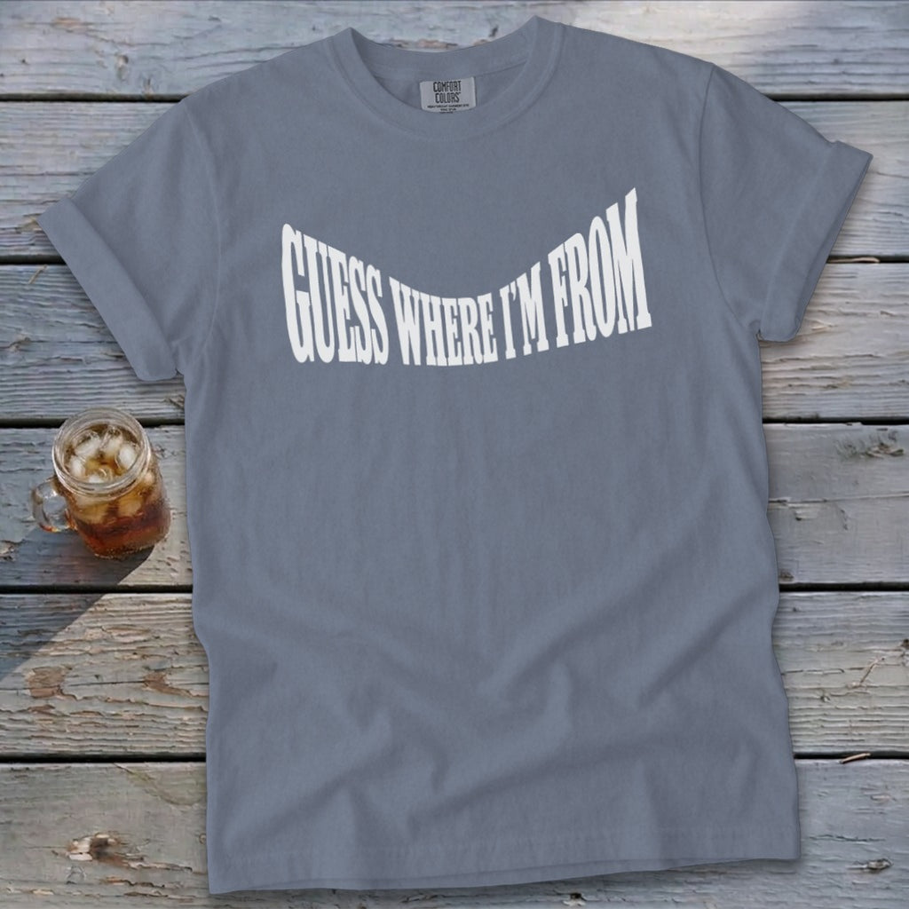 Gray t-shirt with white text "GUESS WHERE I'M FROM" and a glass of iced tea.