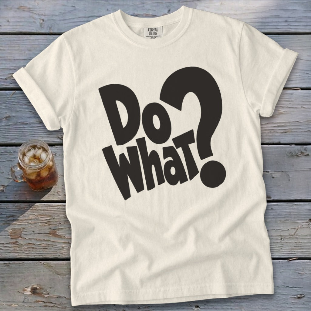 Off-white t-shirt with rolled sleeves featuring the bold black text "Do What?" and a glass of iced tea on a wooden background.