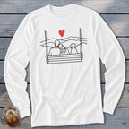 Couple and dog on a swing with a heart and mountain background.
