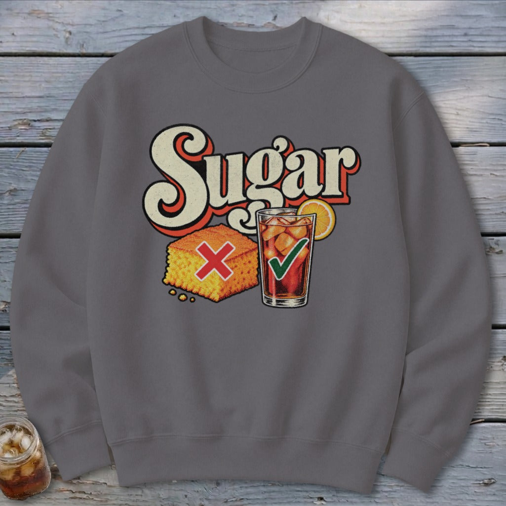 A dark gray crewneck sweatshirt featuring a graphic with retro text reading Sugar, cornbread marked with a red X, and iced tea with a green checkmark.