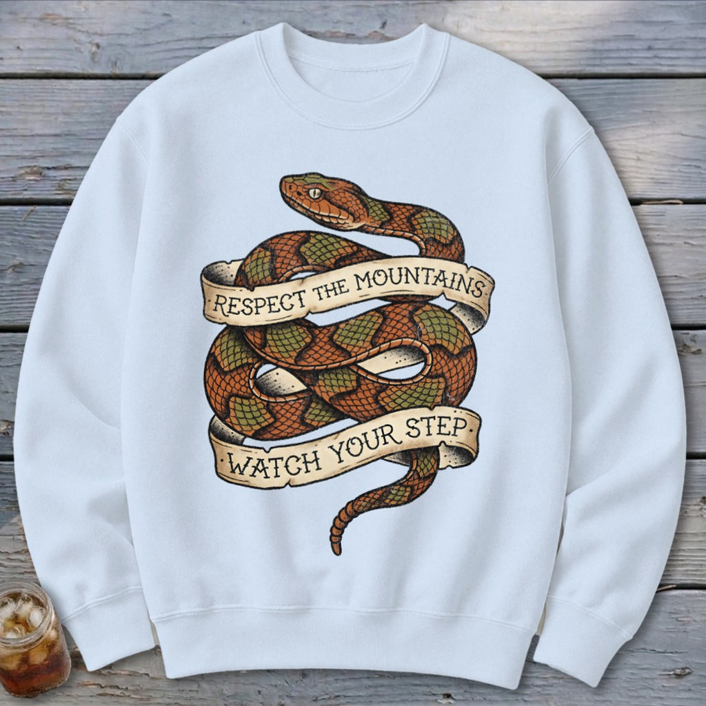 White sweatshirt with coiled snake graphic and banners reading "Respect the Mountains Watch Your Step."