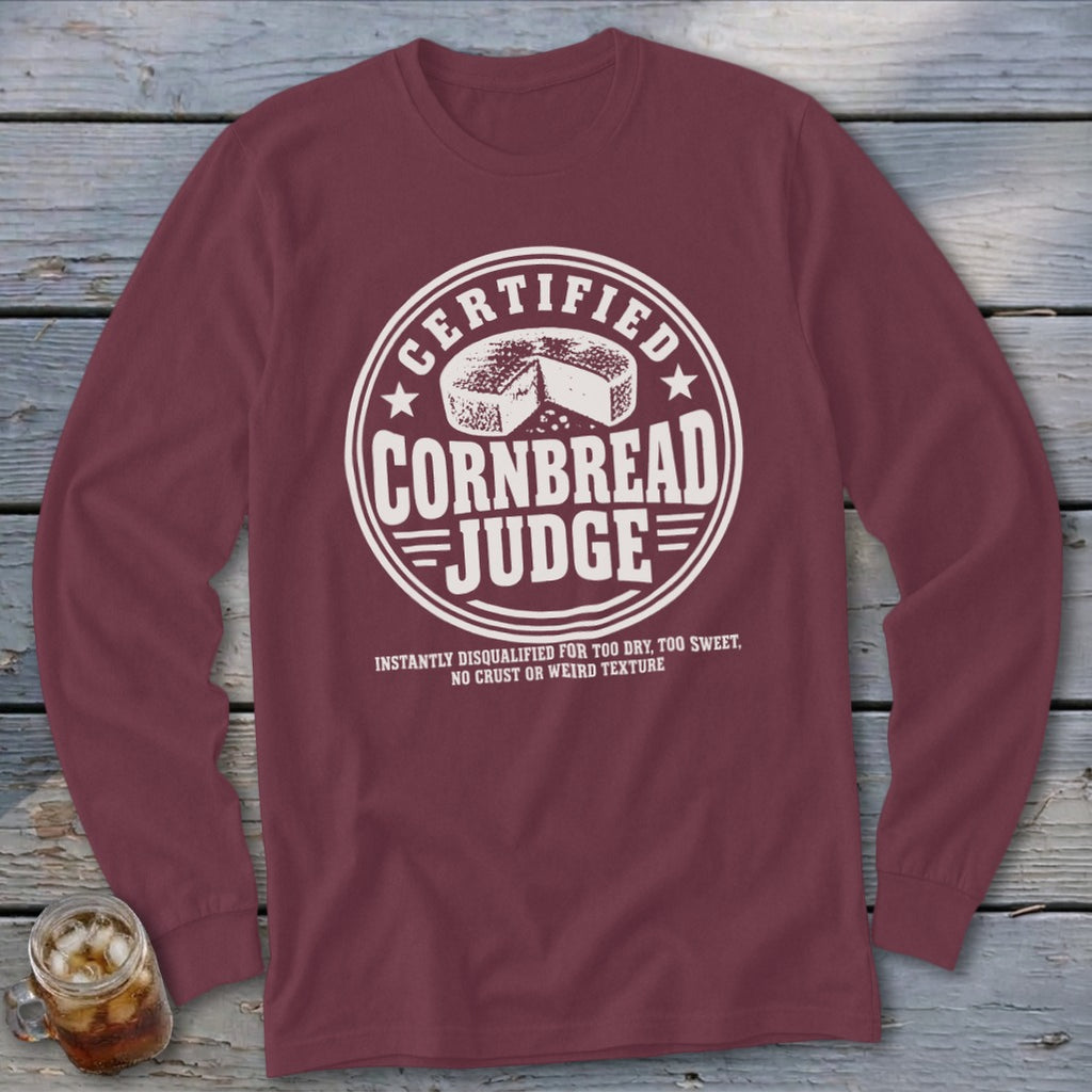 Maroon long-sleeve t-shirt with a white circular graphic reading Certified Cornbread Judge and a cornbread wheel.
