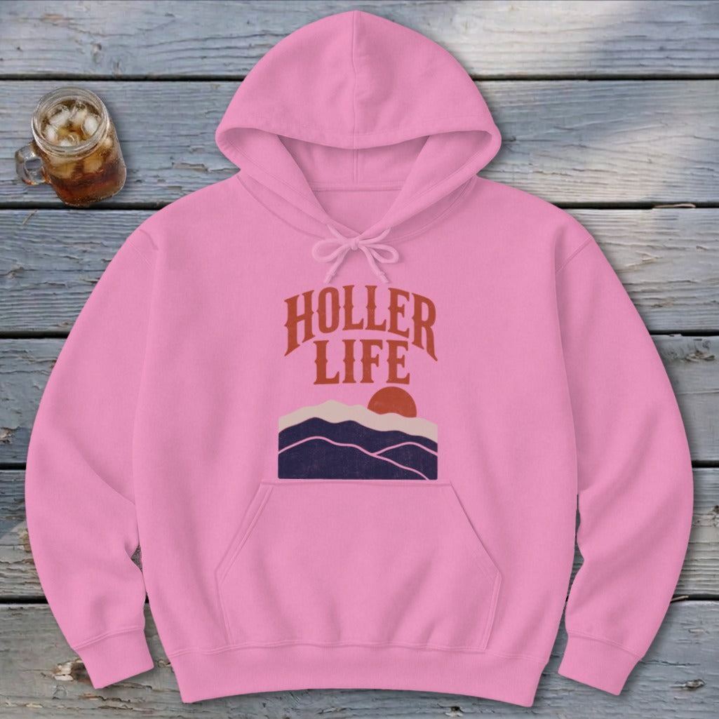 Pink hoodie featuring a graphic of mountains, sunset, and the text HOLLER LIFE.