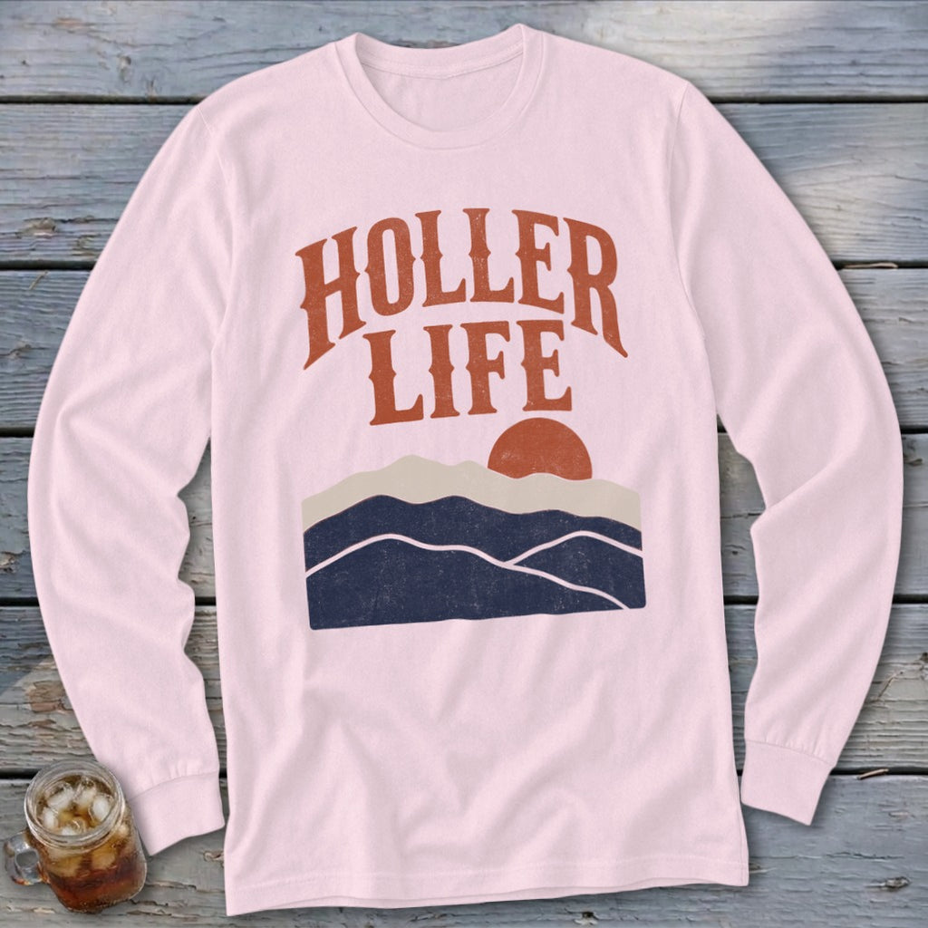 Light pink long-sleeve t-shirt with the text HOLLER LIFE, a sun, and dark blue mountain silhouettes.