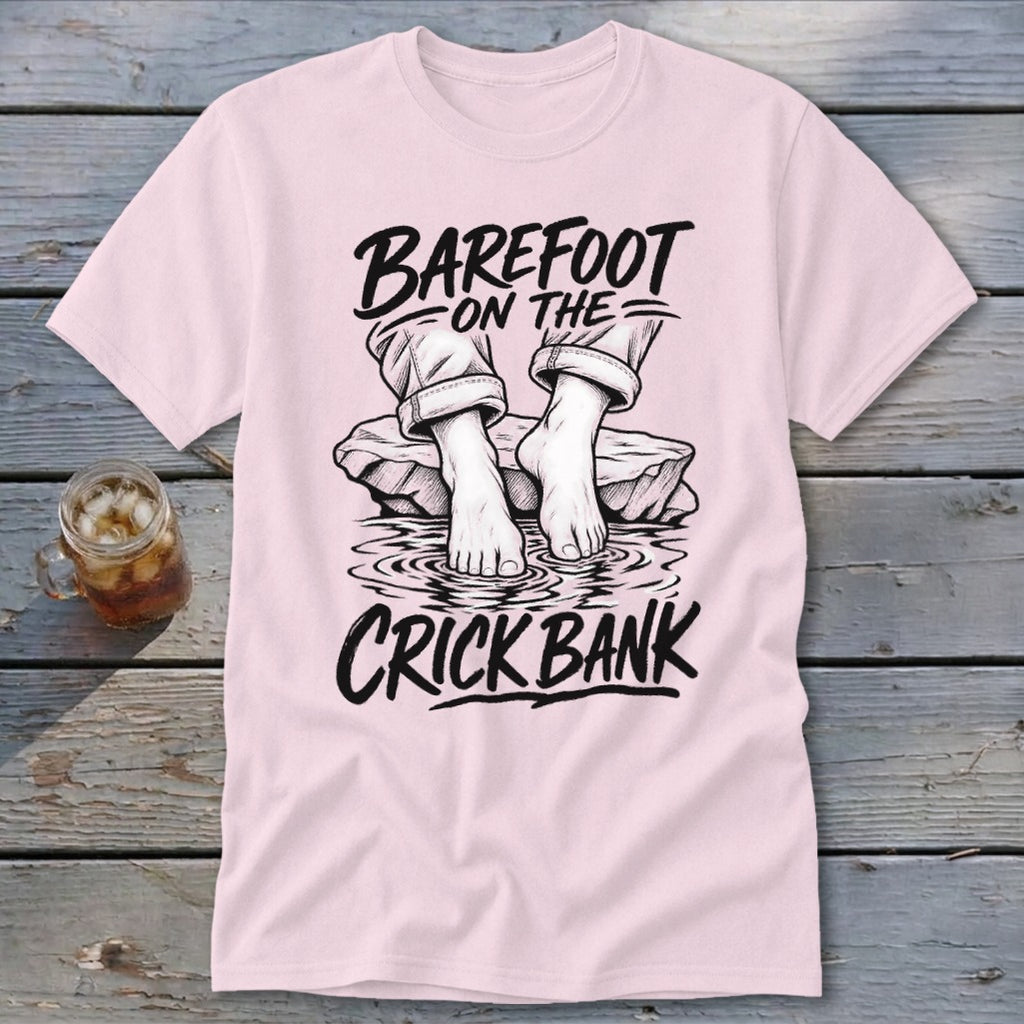 Pink t-shirt with black graphic of feet in water and text "Barefoot on the Crick Bank".