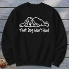 A black crewneck sweatshirt with a white graphic of a sleeping hound dog and the text That Dog Won't Hunt.
