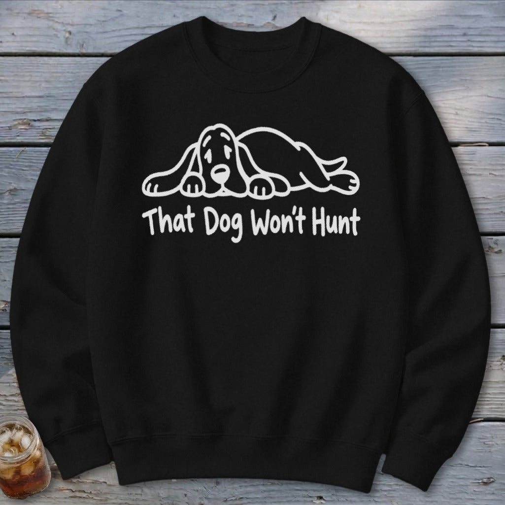 A black crewneck sweatshirt with a white graphic of a sleeping hound dog and the text That Dog Won't Hunt.