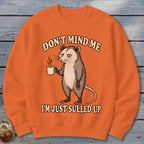 Orange sweatshirt with opossum and text "Don't mind me, I'm just sulled up."