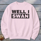 Light pink crewneck sweatshirt with the black text WELL I SWAN printed across the chest.