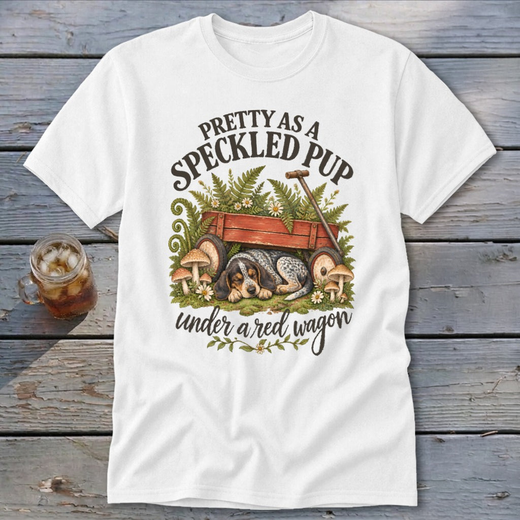 T-shirt with speckled puppy sleeping under a red wagon with ferns and mushrooms.