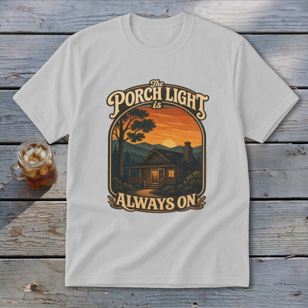 Light grey t-shirt with graphic: "The Porch Light Is Always On" above a cabin at sunset.