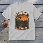 Light grey t-shirt with graphic: "The Porch Light Is Always On" above a cabin at sunset.