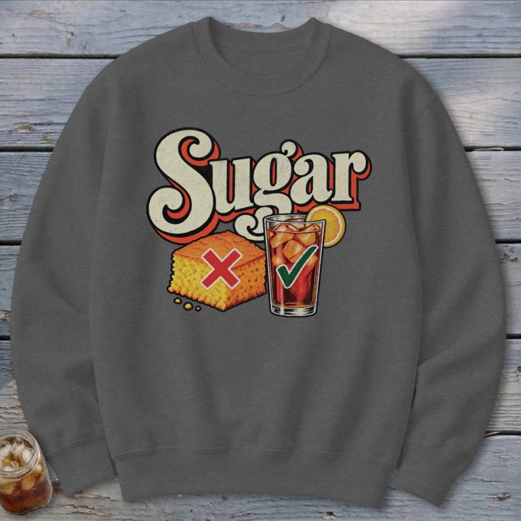A dark gray crewneck sweatshirt featuring a graphic with the text Sugar, a cornbread piece with a red X, and a glass of iced tea with a green checkmark.