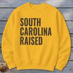 Yellow crewneck sweatshirt with "South Carolina Raised" text.