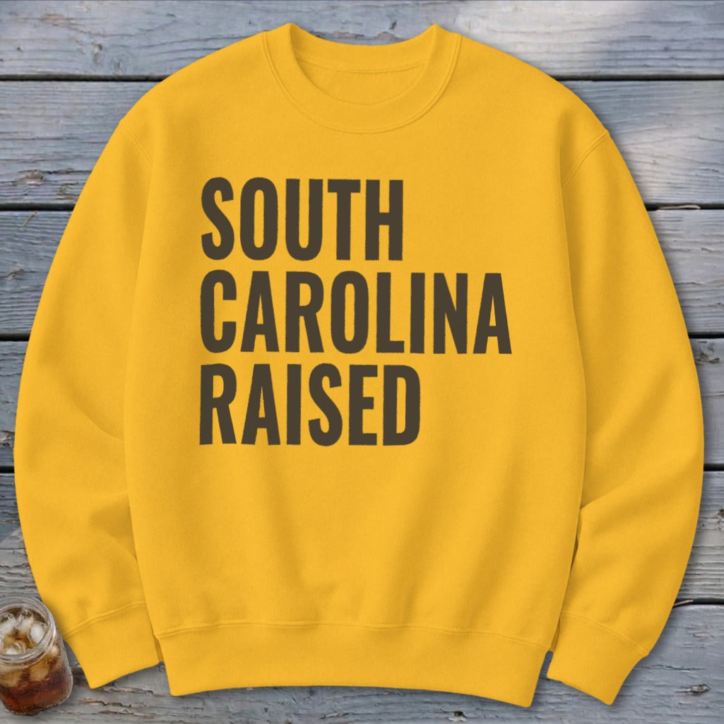Yellow crewneck sweatshirt with "South Carolina Raised" text.