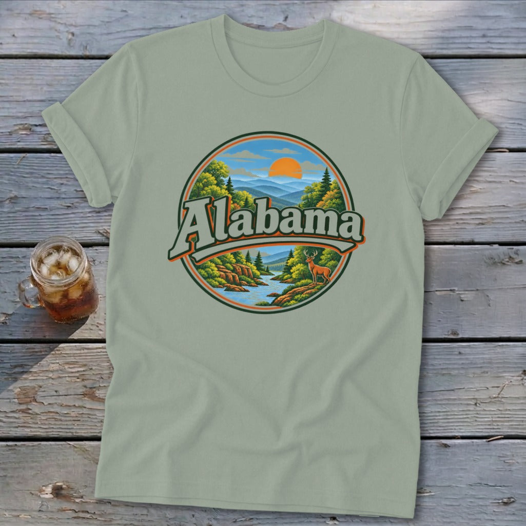 Light green t-shirt with circular graphic depicting a river, deer, mountains, and "Alabama" text.