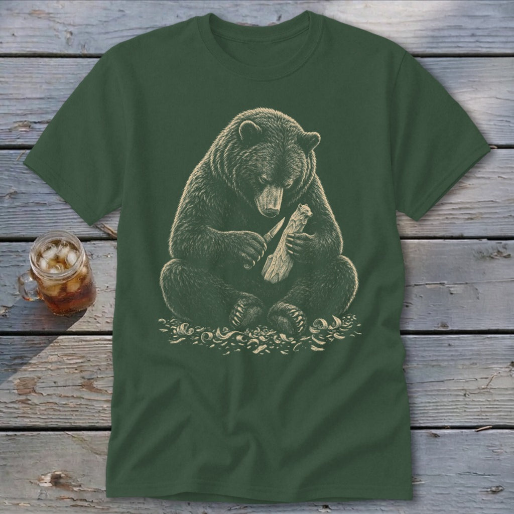 Bear carving wood with a knife, depicted on a dark green t-shirt.