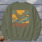 Green sweatshirt with a graphic of mountains, sun, clouds, and text "Mountain Summers".