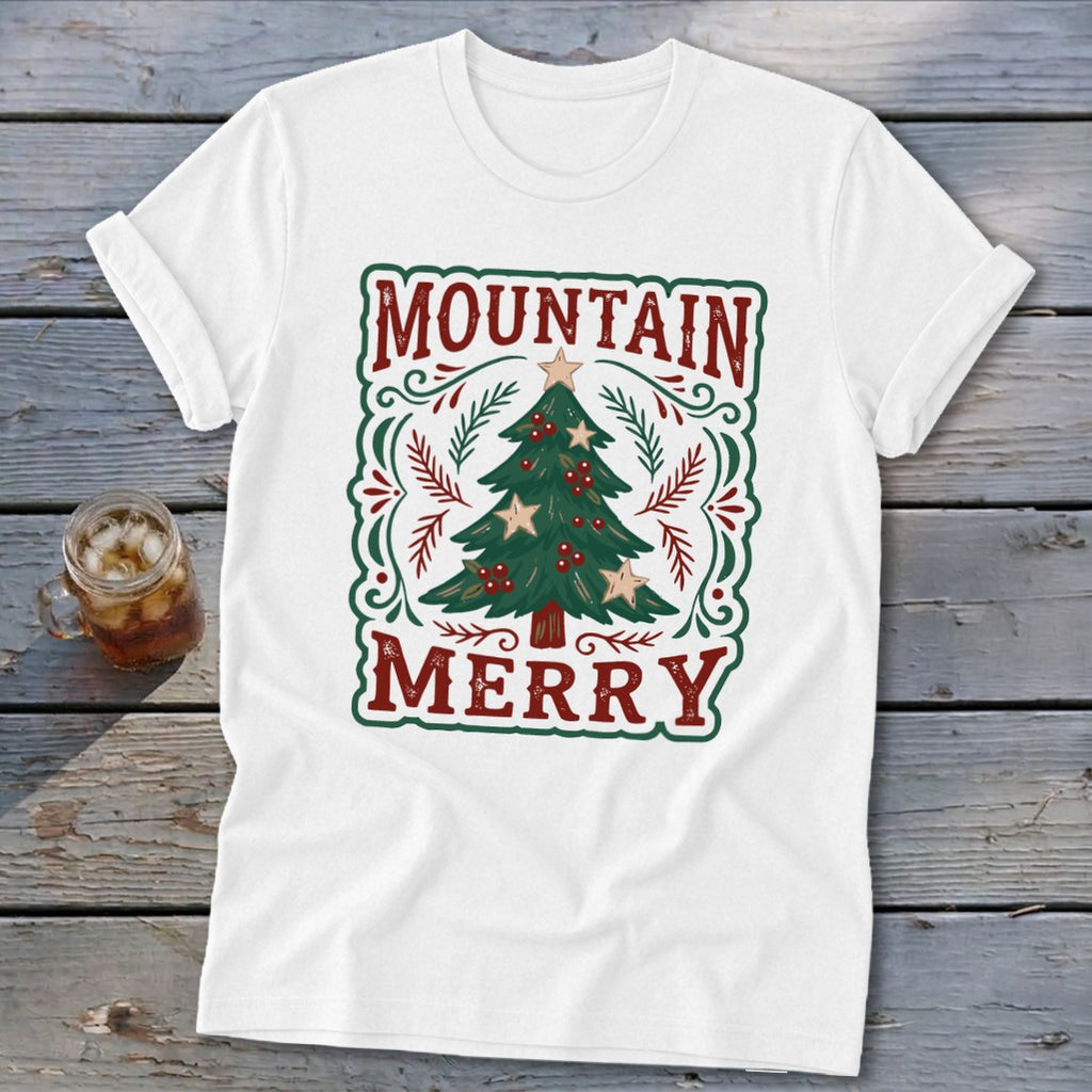 White t-shirt featuring a green and red Christmas tree design with the text Mountain Merry.