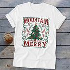 White t-shirt featuring a green and red Christmas tree design with the text Mountain Merry.