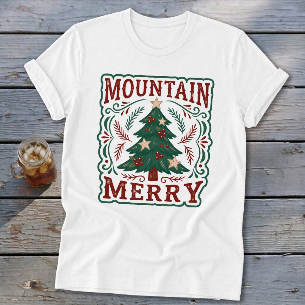 White t-shirt featuring a green and red Christmas tree design with the text Mountain Merry.