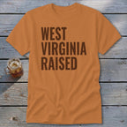 Orange t-shirt with brown text "WEST VIRGINIA RAISED".