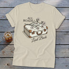 Cream t-shirt with illustration of suitcase and flowers, text "ALL ROADS Lead Back".