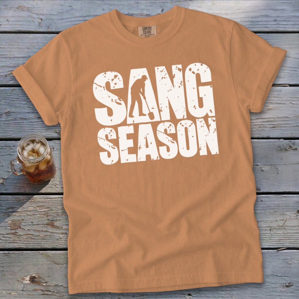 A camel-colored t-shirt with rolled sleeves displaying distressed white text reading SANG SEASON across the chest.