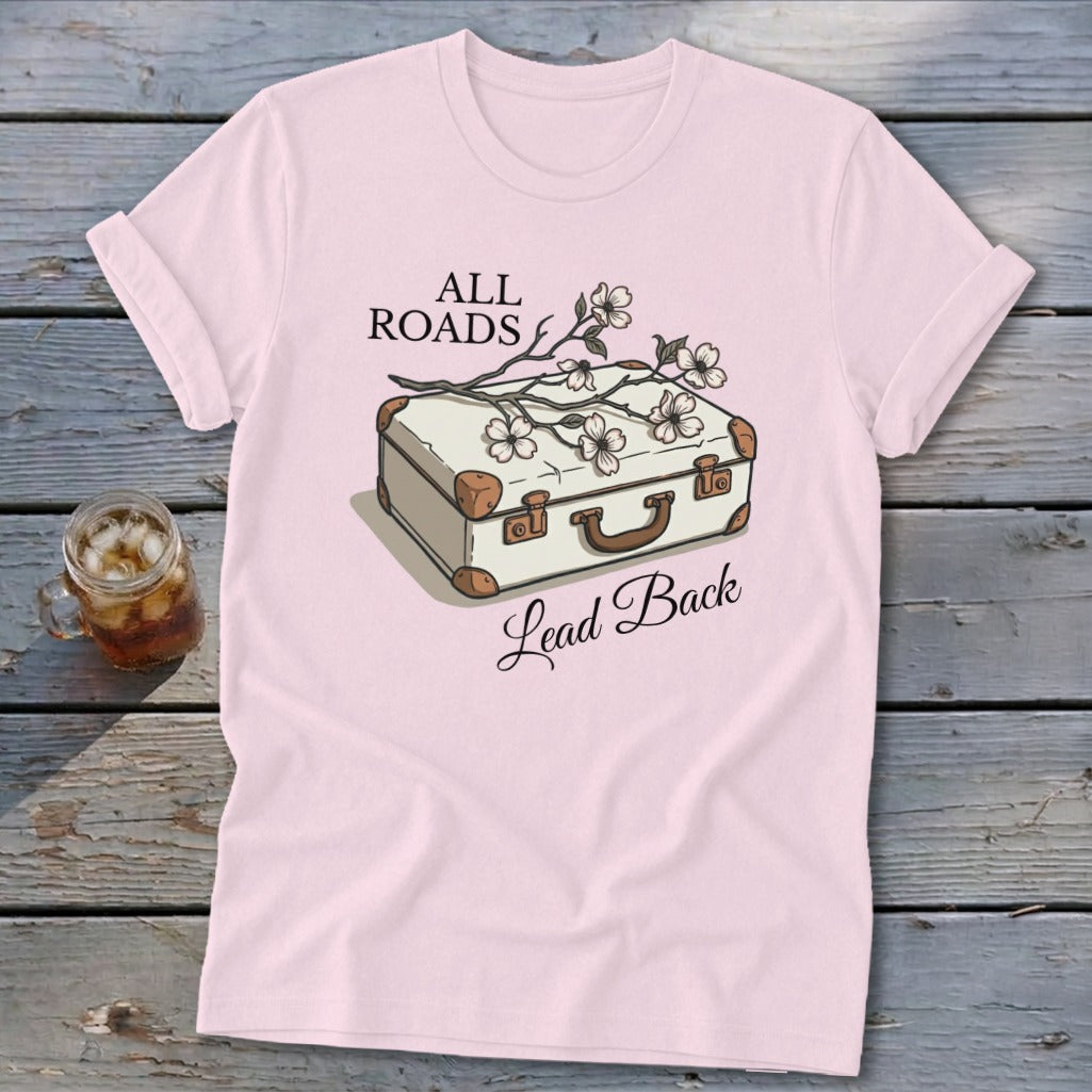 Light pink t-shirt with vintage suitcase graphic and text "ALL ROADS Lead Back".