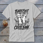 Shirt with "Barefoot on the Crick Bank" text and illustration of bare feet.