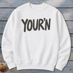 White sweatshirt with dark gray "YOUR'N" text centered on the chest.