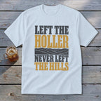 White t-shirt with text "LEFT THE HOLLER NEVER LEFT THE HILLS" and mountain graphic.