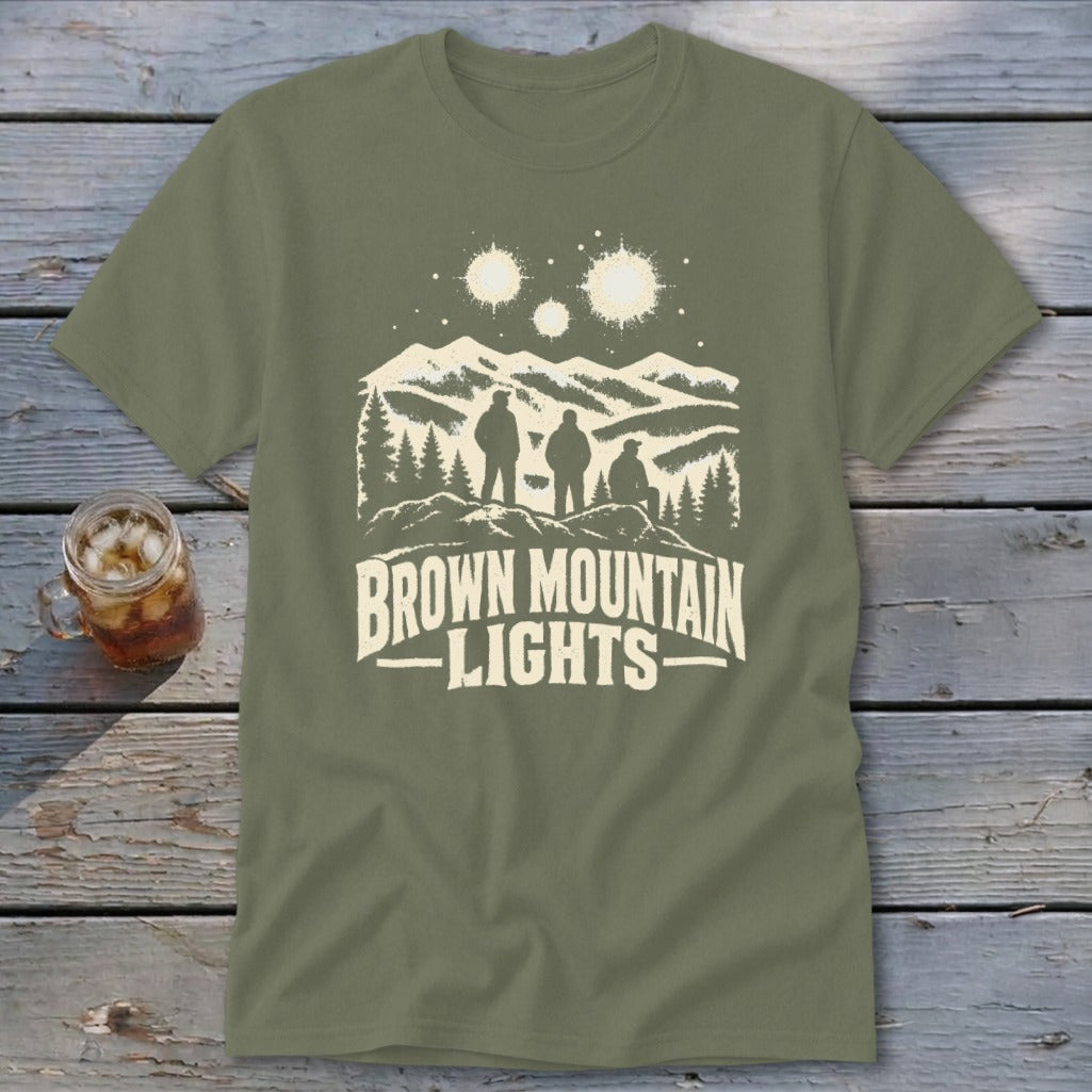 An olive green t-shirt featuring a mountain graphic with glowing lights and the text Brown Mountain Lights.