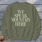 Olive green crewneck sweatshirt with "WE SPEAK MOUNTAIN HERE" printed in cream.