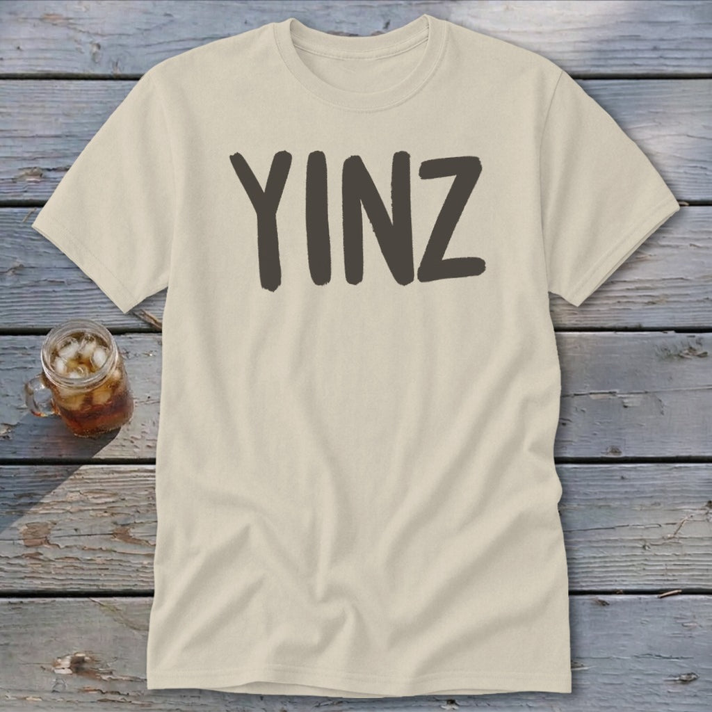 Cream t-shirt with "YINZ" printed in dark gray on the front.