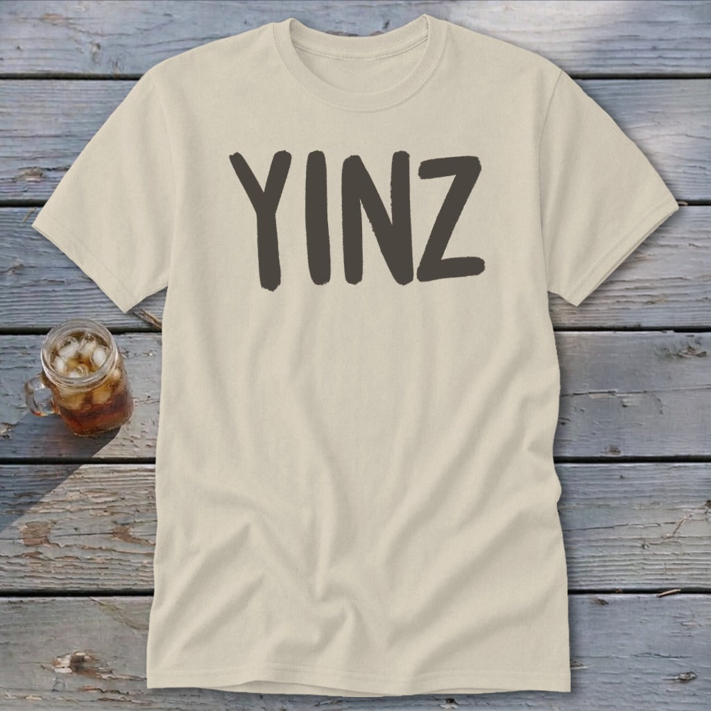 Cream t-shirt with "YINZ" printed in dark gray on the front.