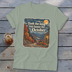 T-shirt graphic with text "Took the long way home for October" over autumn mountains.
