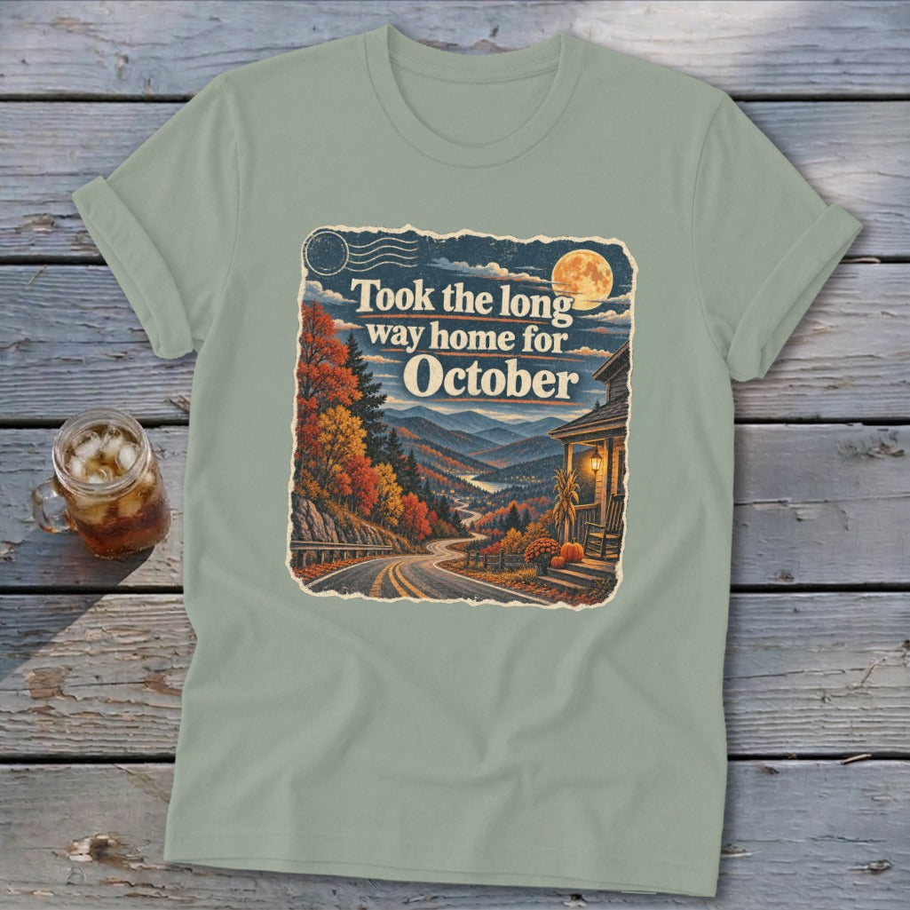 T-shirt graphic with text "Took the long way home for October" over autumn mountains.