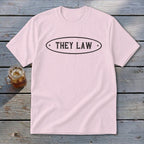 Pink t-shirt with black text "THEY LAW" inside an oval border.