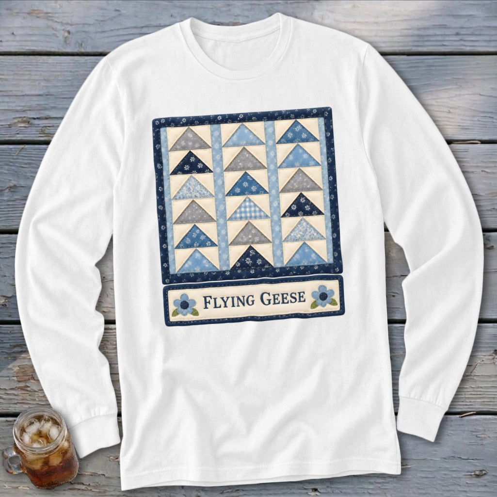 White long-sleeve shirt with a blue and grey Flying Geese quilt block design.