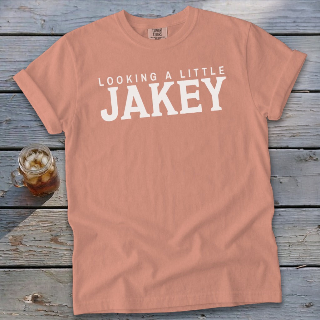 Peach t-shirt with white text "LOOKING A LITTLE JAKEY" and a glass of iced tea.