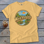Yellow t-shirt featuring a circular graphic of West Virginia landscape with deer and river.