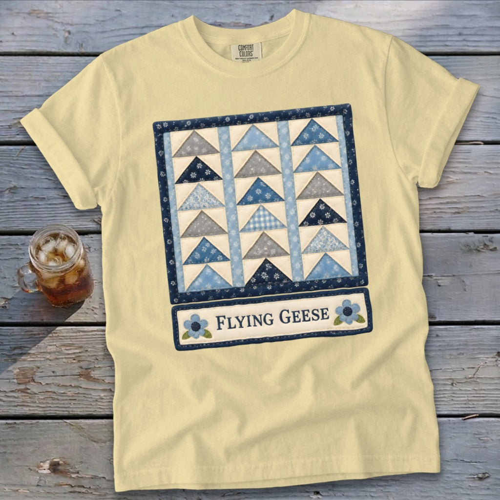 Yellow t-shirt with a blue and gray flying geese quilt design and text.